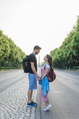 Fototapeta premium side view of couple holding hands and looking at each other at street in Berlin, Germany