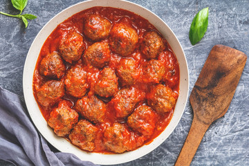 Meatballs with tomato sauce in a white iron pan. Modern style. Top view.