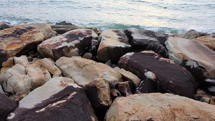 Large colorful rocks lining on a seashore