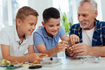 Young genius. Nice positive boys building a robot while enjoying engineering