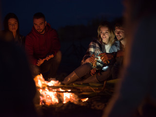 Couple enjoying with friends at night on the beach