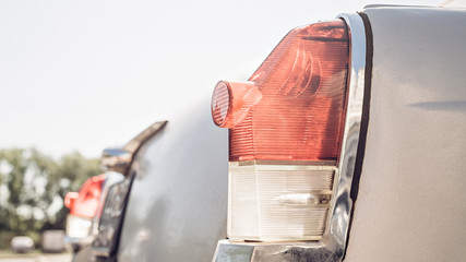Rear lights of a vintage car on a sky background