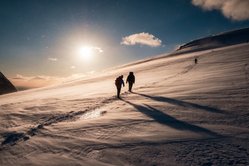 Climbers with backpack climbing on snowy mountain
