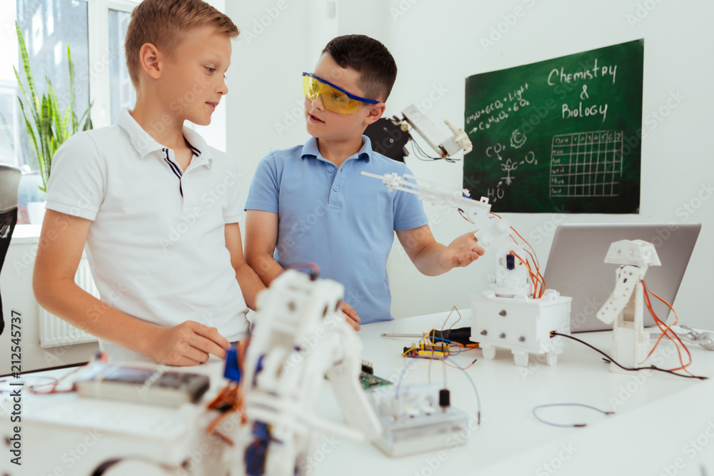 Wall mural our project. smart nice boys talking to each other while discussing their science project