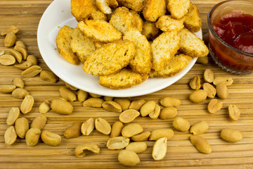 Snack, nut, on a plate. Wooden table. Salty food for beer