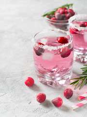 Cranberries cocktails with ice, berries and rosemary