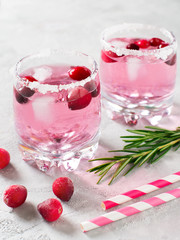 Cranberries cocktails with ice, berries and rosemary