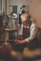 An elderly shoemaker in studio