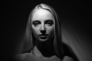 Portrait of a beautiful blonde on a black background.