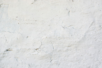 Closeup fragment of white shabby stone wall