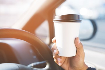 people person drinking paper cup coffee of hot holding hand in a car in the morning not sleepy be energetic while driving. transportation and vehicle concept. empty copy space for text.