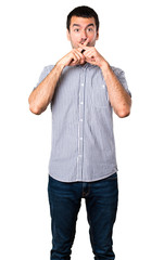 Handsome man making silence gesture on isolated white background