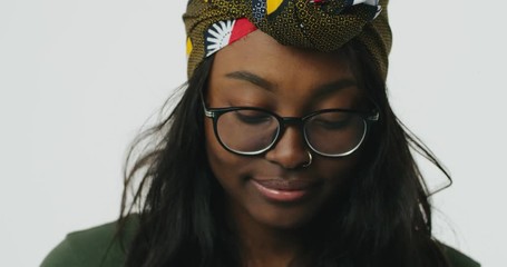 Close-up portrait of beautiful African woman in glasses smiling on camera.