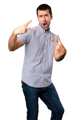 Fototapeta premium Handsome man making victory gesture on isolated white background