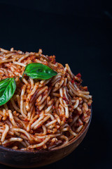 Italian spaghetti with a bolognese tomato meat sauce and basil in a plate. Copy space. Italian food concept.