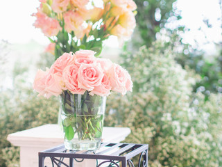 Close up pink rose flowers on green background In vase glass bottle wedding day.