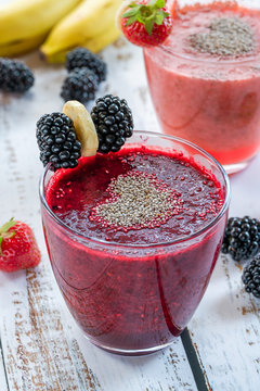 Blackberry and strawberry smoothies garnished with chia seeds and fresh fruit. Healthy breakfast idea.