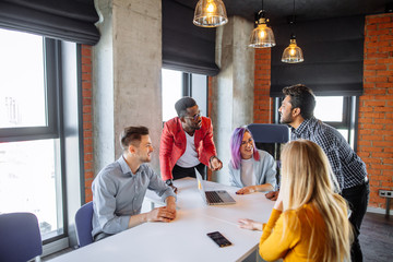 Multiracial creative young designers having a business discussion at modern office meeting room. Corporate Concept. - Powered by Adobe