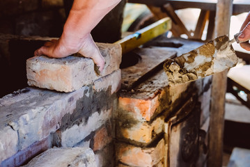 Restoration repair of the old village furnace. Bricklaying.