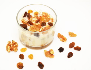 White yogurt with nuts and raisin on white background. Healthy breakfast