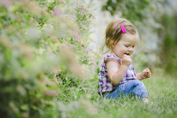 The small child sits on the grass