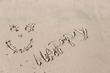 Handwrited face on the sand at the beach. Symbol Smile on the sand