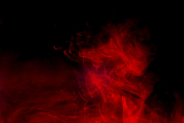 Red smoke isolated on black background.