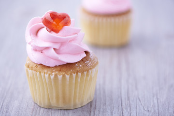 Two cupcakes on wooden background