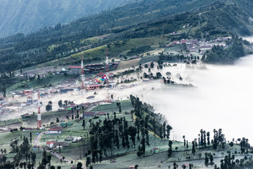village and forest in morning fog on mountain