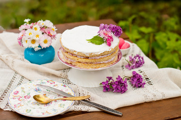 Sweet dessert, wedding cake with flowers and fruits on the background of nature