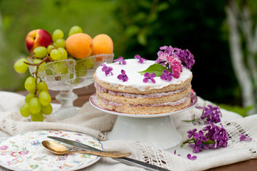 Sweet dessert, wedding cake with flowers and fruits on the background of nature