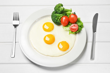 fried eggs with fresh vegetables on the table
