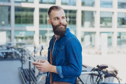 Young bearded man looking back over his shoulder
