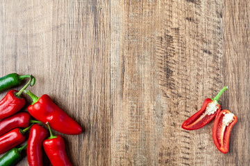 Red and green chilli pepper on wooden table with copy space