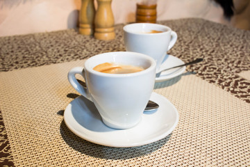 Still-life composition, coffee cups, white serving plates, small metal spoons