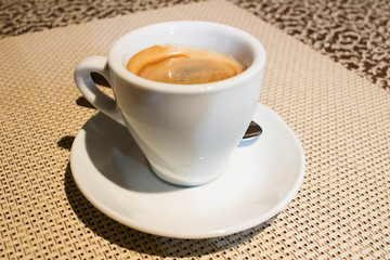 Still-life composition, white coffee cup, serving plate, small metal spoon