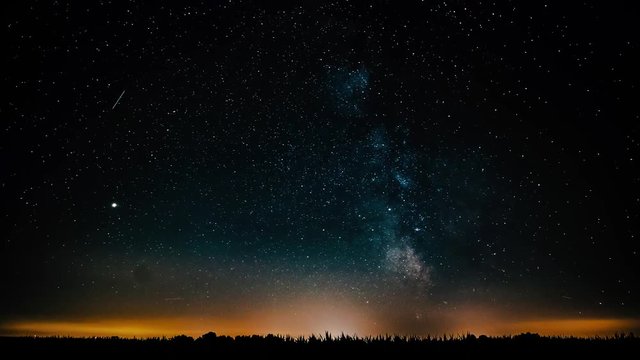 4K time lapse of milky way moving over a corn field