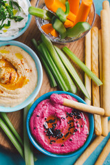 Fresh vegetarian dips in small bowls on table