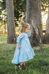 Little girl in blue dress walk in park