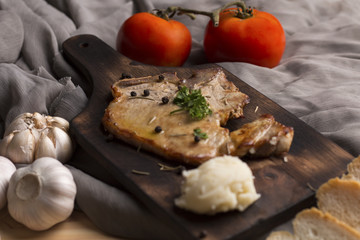 Steak,tomato,parsley, garlic,black pepper and wine on wood and fabric.Copy space.