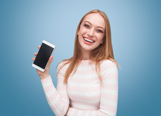 Happy young woman showing smartphone in hand 