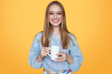 Woman smiling with cup in studio