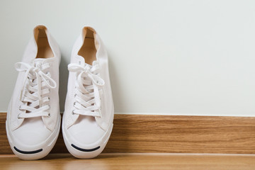 White sneakers on wood background, concept Copy space