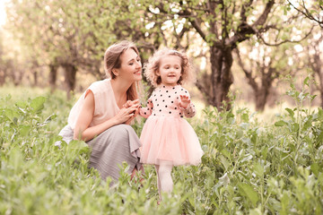 Fototapeta premium Happy mother holding child girl 3-4 year old outdoors. Motherhood.