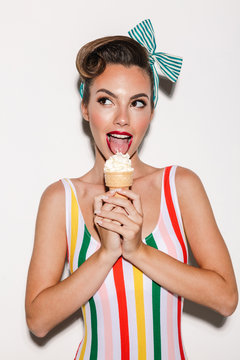 Naklejki Beautiful pin up woman eating ice cream.