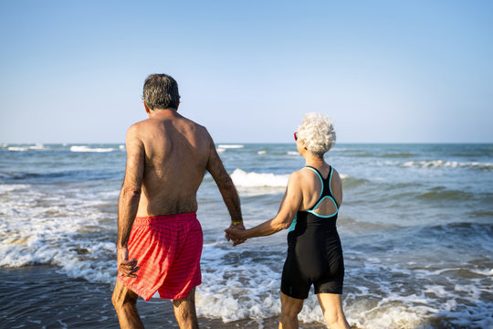 Mature couple walking into the water