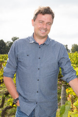 Young winemaker man standing at vineyard on sunny day