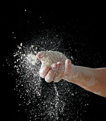 Obraz na płótnie Canvas hand with flour on a black background