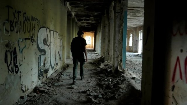 Tourist makes photos and explores corridor of abandoned old building