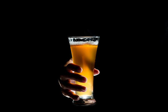 Hand Holding Glass Of Craft Beer On Black Background